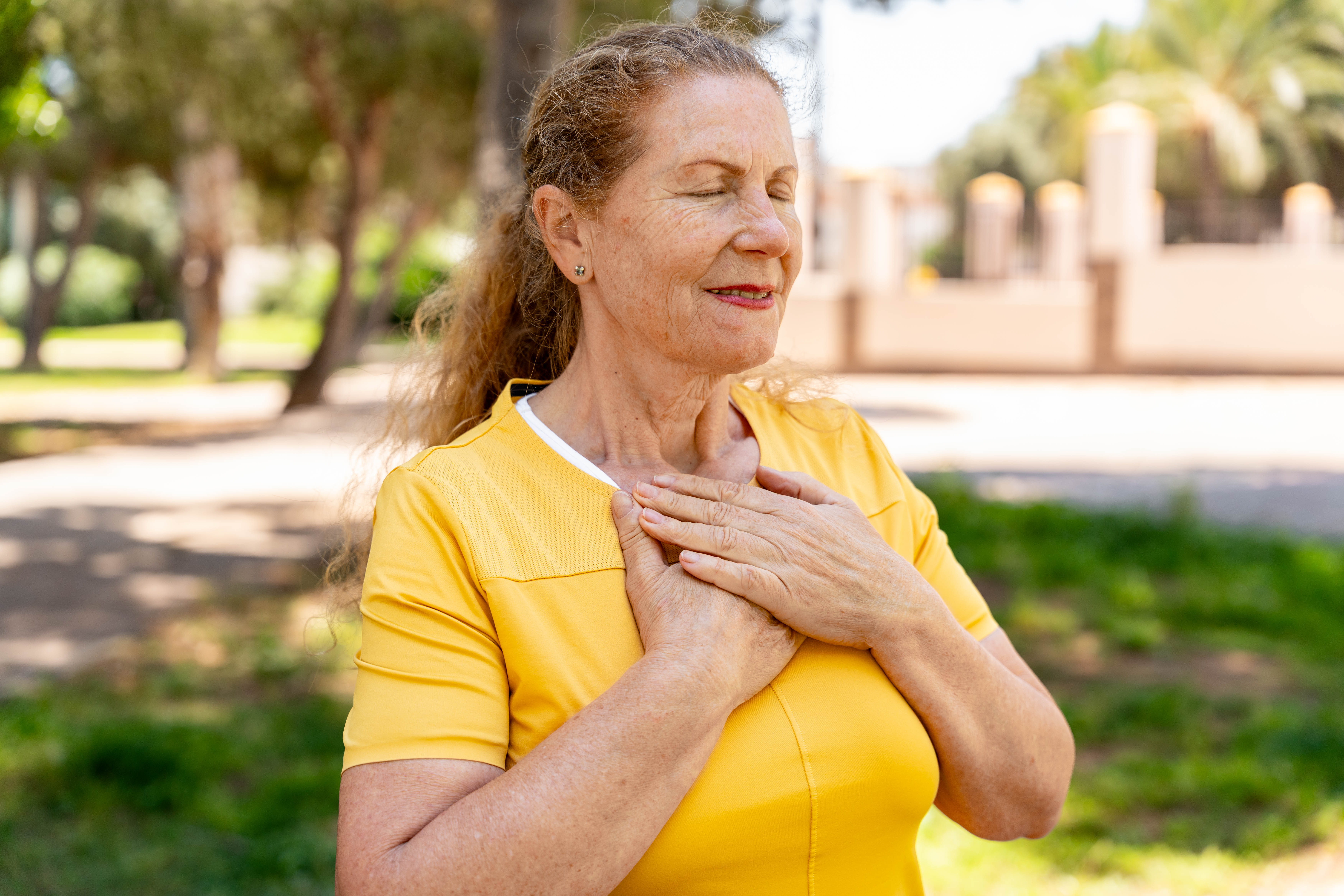 Senior woman practicing calm breathing in a park